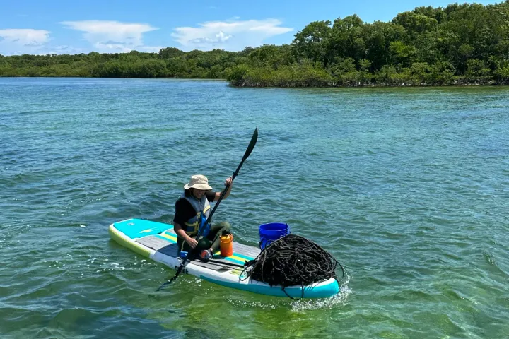 a man riding on the back of a boat in a body of water
