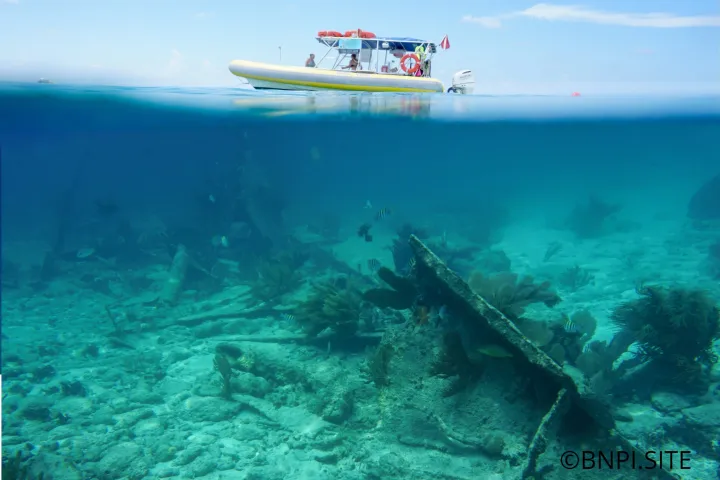 shipwreck with a snorkel boat in the background