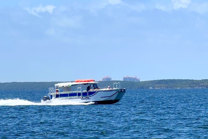 Motorboat speeding on the ocean under clear blue sky.