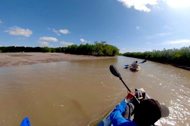 a man riding on the back of a boat in a body of water